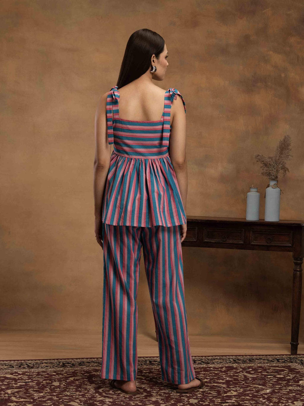 Woman wearing a striped cotton outfit standing perfect for a beach vacation, traveling, or daily wear.